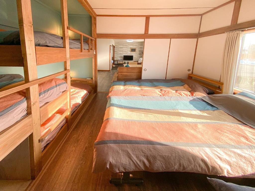 a bedroom with two bunk beds and a window at Port Front ポートフロント 釣りに最適 in Shikyū