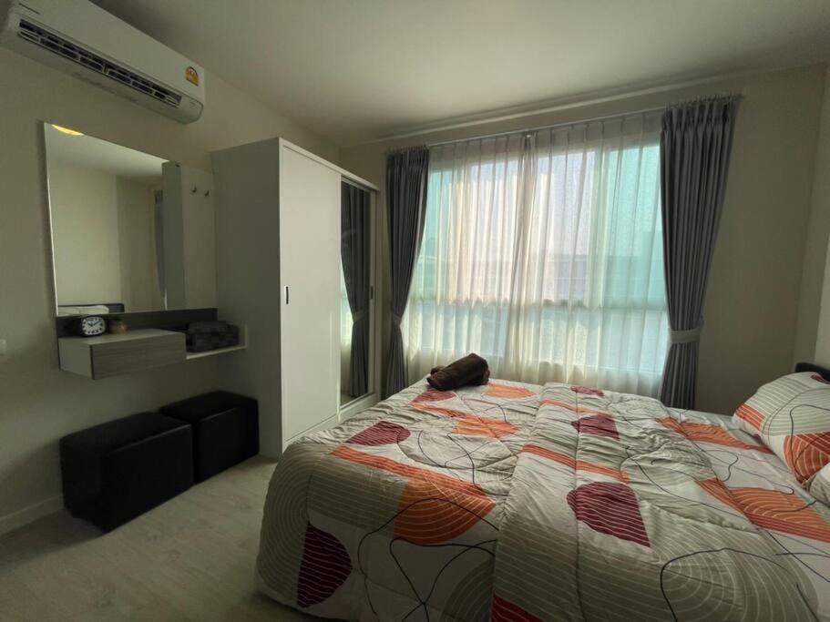 a bedroom with a bed and a large window at D condo sign A72 in Chiang Mai