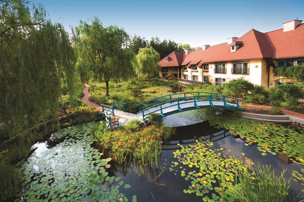 a bridge over a pond with water lilies at Mirbeau Inn & Spa - Skaneateles in Skaneateles