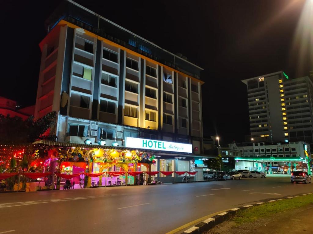 une rue de la ville avec un hôtel la nuit dans l'établissement HOTEL MALAYSIA, à Sibu