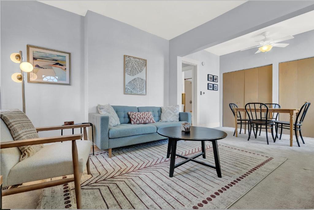 uma sala de estar com um sofá azul e uma mesa em Cozy Cottage in the Heart of Hyde Park home em Cincinnati