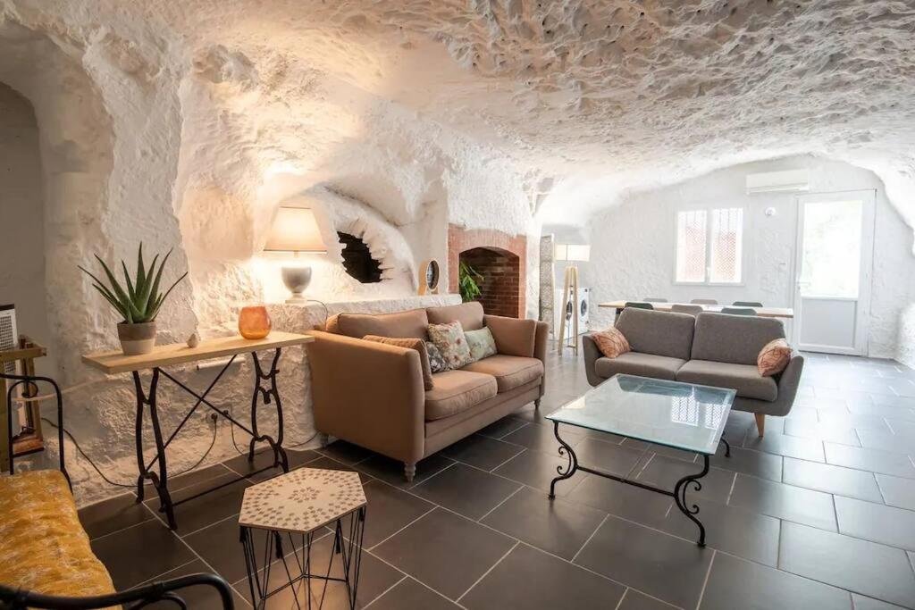 uma sala de estar com um sofá e uma mesa em Maison troglodyte - Le Cerisier Perché em Luynes