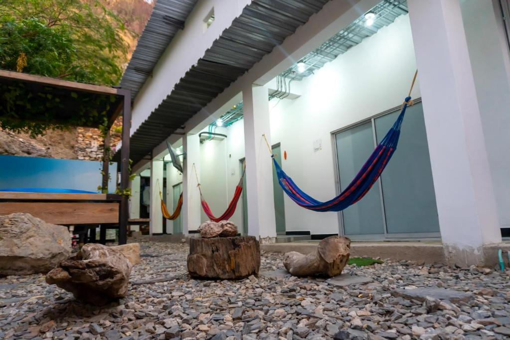 a group of hammocks in front of a building at Hotel Family House Rodadero in Santa Marta