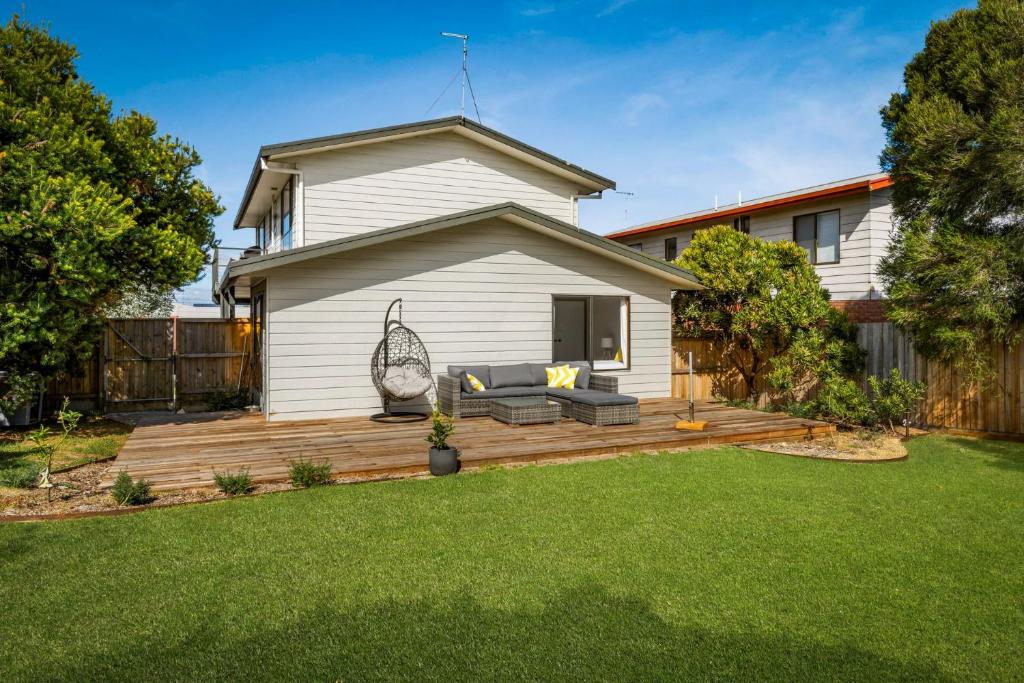 ein Hinterhof mit einer Holzterrasse vor einem Haus in der Unterkunft Badhuset in Smiths Beach