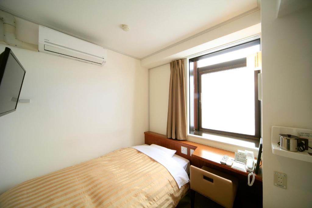 Postel nebo postele na pokoji v ubytování Nagano Daiichi Hotel