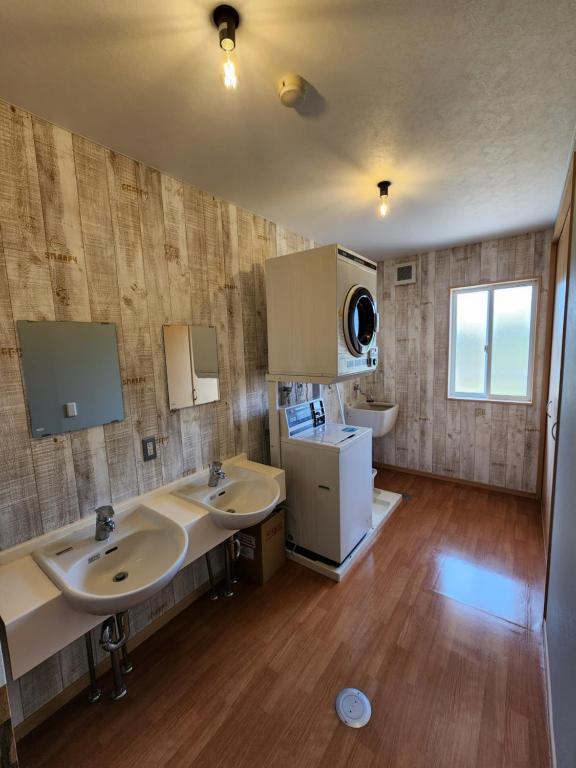 a large bathroom with two sinks and a refrigerator at Cycle Guest House SHIOKAZE in Setoda