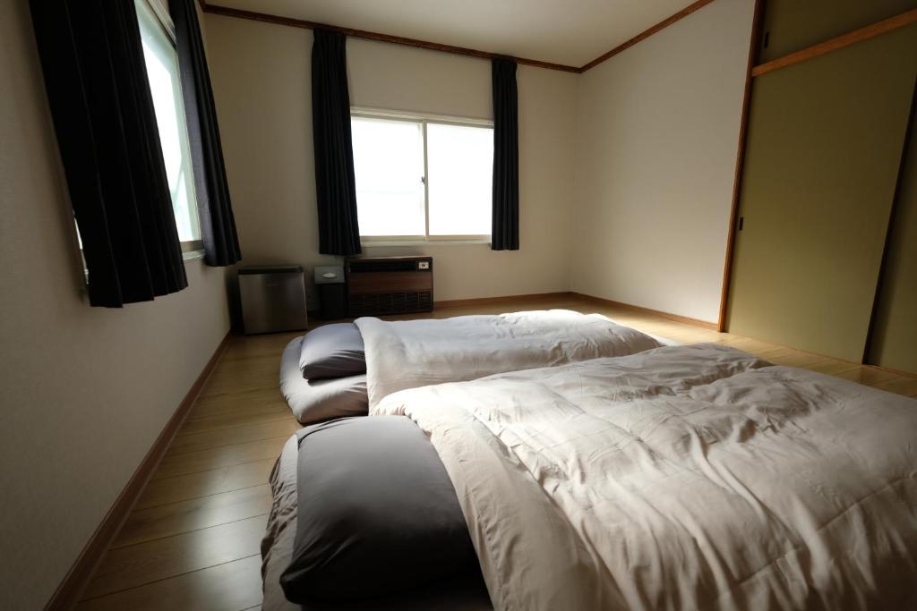 a room with two beds and two windows at Bear Elephant in Rausu