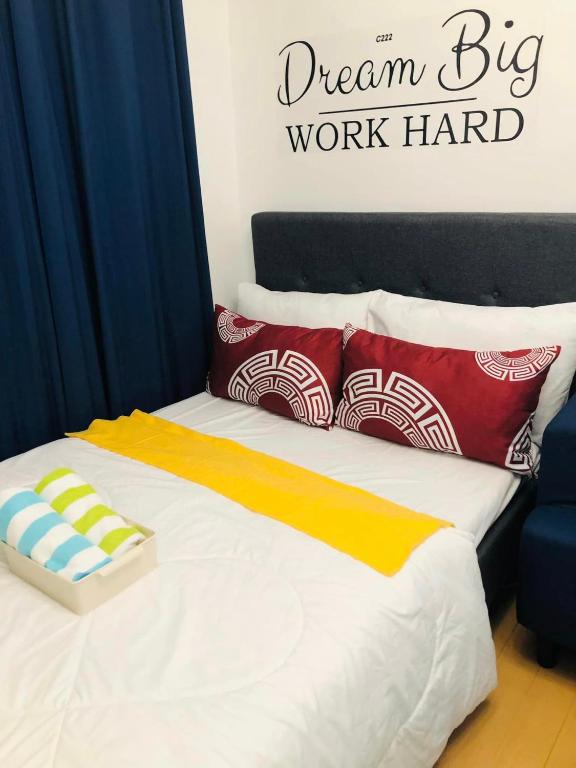 a bed with a big work hard sign on the wall at Avida Tower Sucat, comfortable studio type in Manila