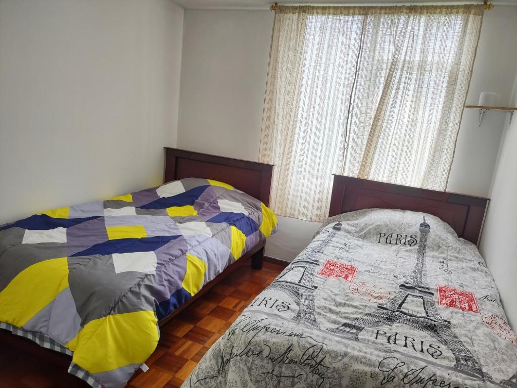 1 dormitorio con 2 camas y ventana en Mi Casa, en Quito