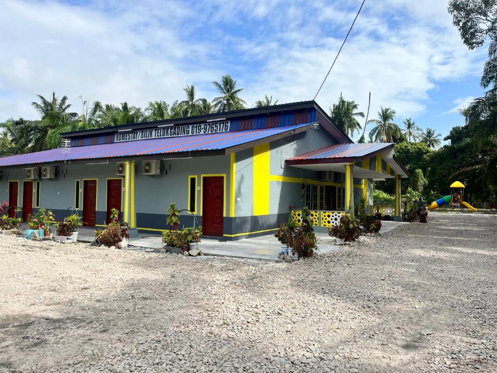 a building with a yellow and blue at Homestay/Bilik Teluk Gading in Kuala Rompin