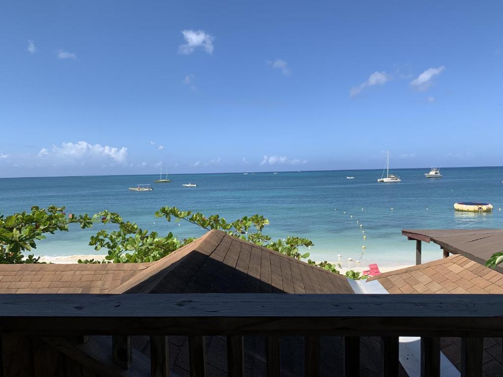 a view of the ocean from the balcony of a resort at Family Comfort in Jamaica - Enjoy 7 miles of White Sand Beach! villa in Negril