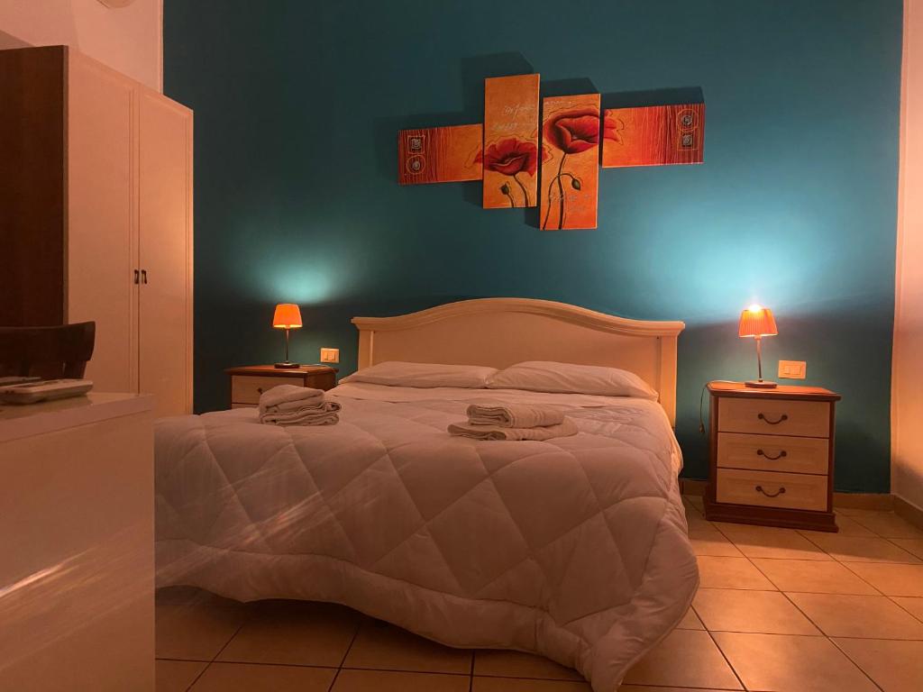 um quarto com uma cama e duas mesas de cabeceira com candeeiros em Gli Agrumi Rooms em Trapani
