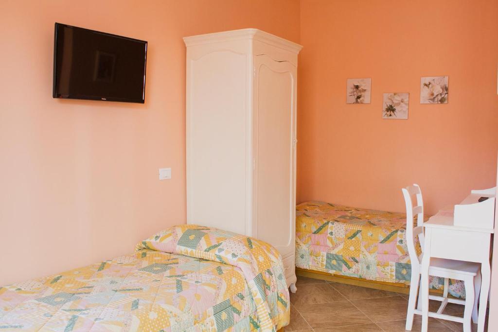 a bedroom with a bed and a tv on the wall at La Papaya in Marina di Pisa