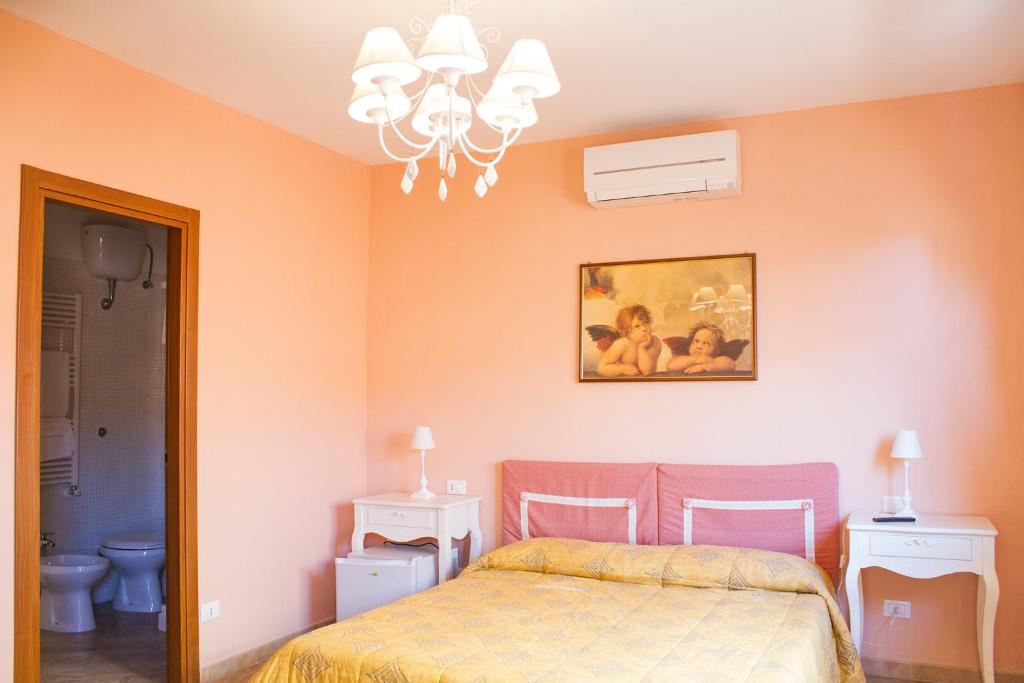 a bedroom with a bed and a painting on the wall at La Papaya in Marina di Pisa