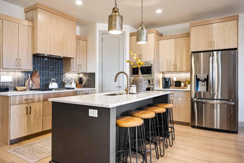 a kitchen with a island with a sink and stools at Casa Lua townhouse in St. George