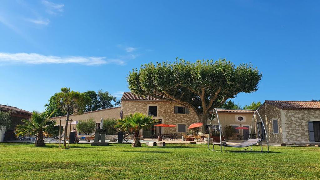 een park met een hangmat voor een gebouw bij Mas de Nonin St Rémy de Provence in Noves