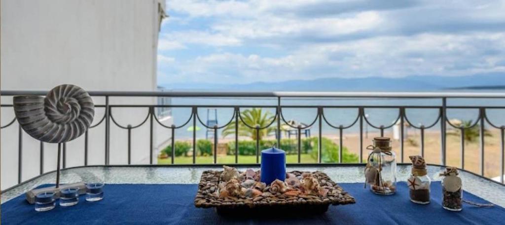 una mesa con una vela azul en la parte superior de un balcón en "SteliosDimitra" House with view in sea of Kantia, en Kandia