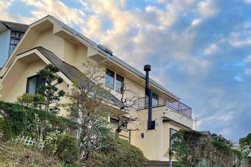 a house with a balcony on the side of it at 雅 南熱海 温泉別荘 Ocean View Hotspring Villa in Ajiro