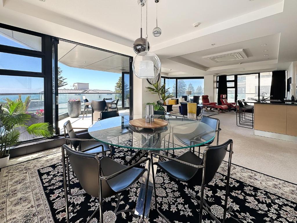 a dining room with a glass table and chairs at Mt Maunganui Main Beach Luxury with Seaviews in Tauranga