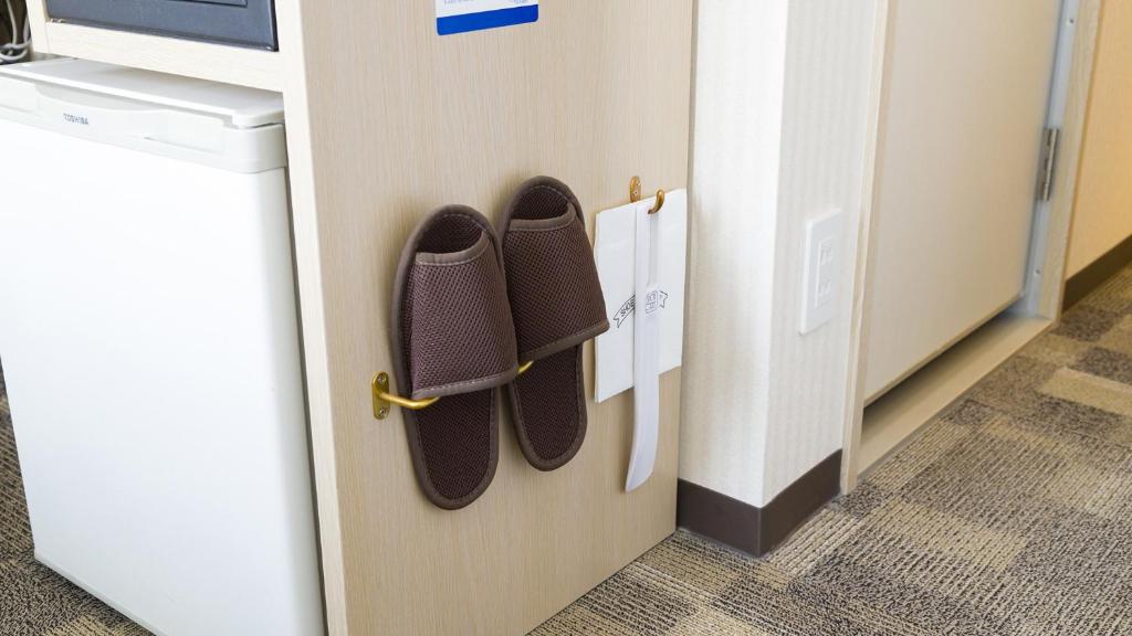 a pair of shoes are hanging on a door at Toyoko Inn Chubu International Airport No1 in Tokoname
