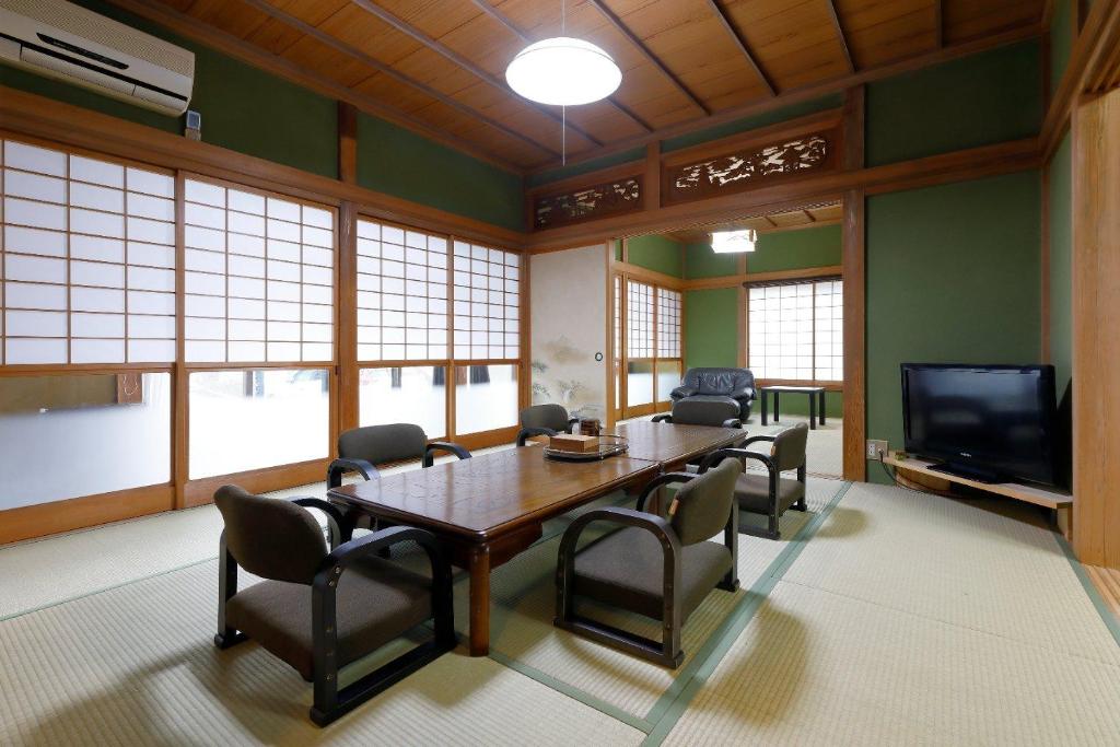 uma sala de jantar com uma mesa e cadeiras e uma televisão em Katori Resonal Sawara em Katori