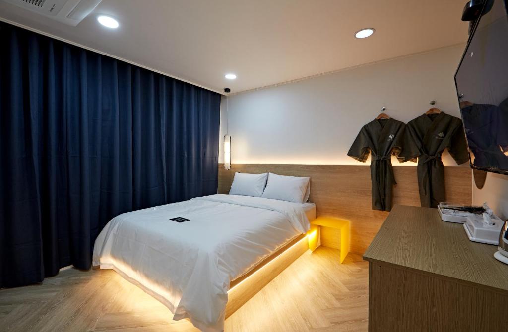 um quarto com uma cama grande e cortinas azuis em Hotel sounds em Jeonju