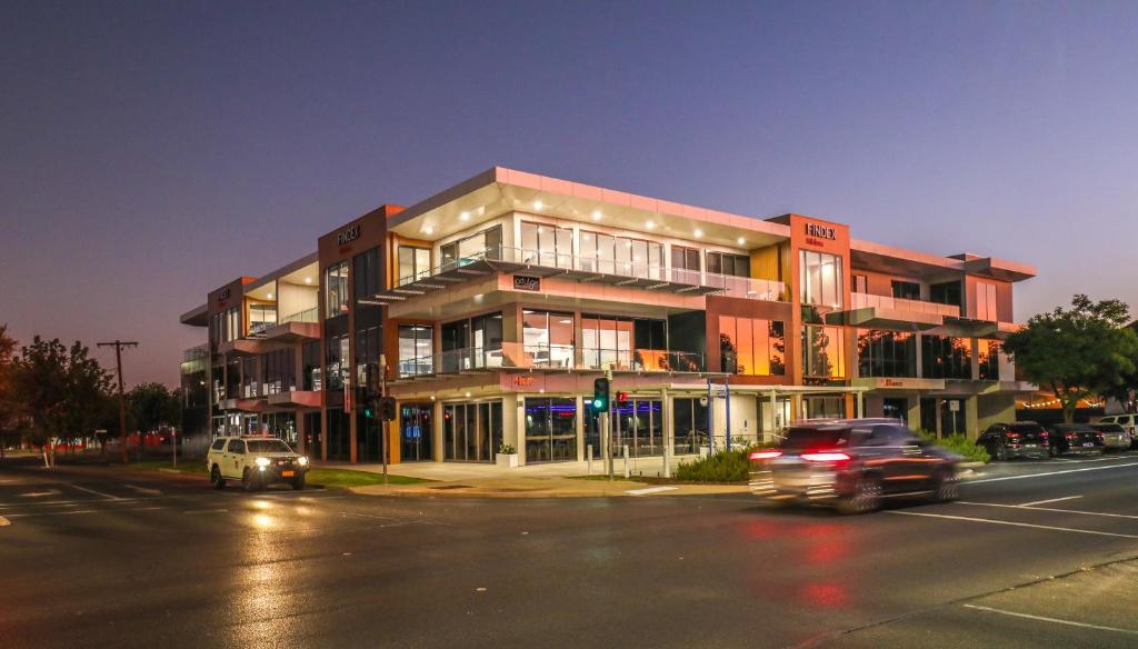 a building on the corner of a street at night at Indulge Apartments - City View Penthouses in Mildura