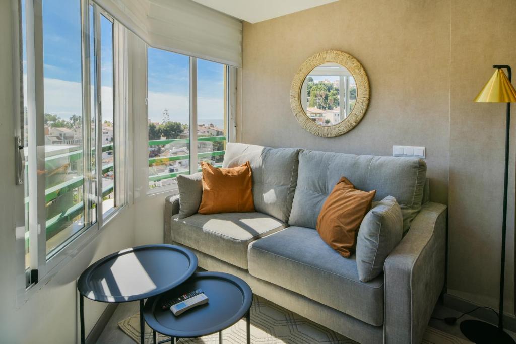 un soggiorno con divano e una grande finestra di Apartamento a un paso del mar a Málaga