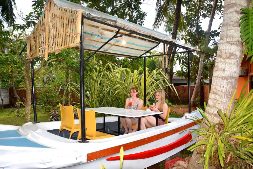 Dos mujeres sentadas en una mesa en un barco en S P City Resort, en Anuradhapura