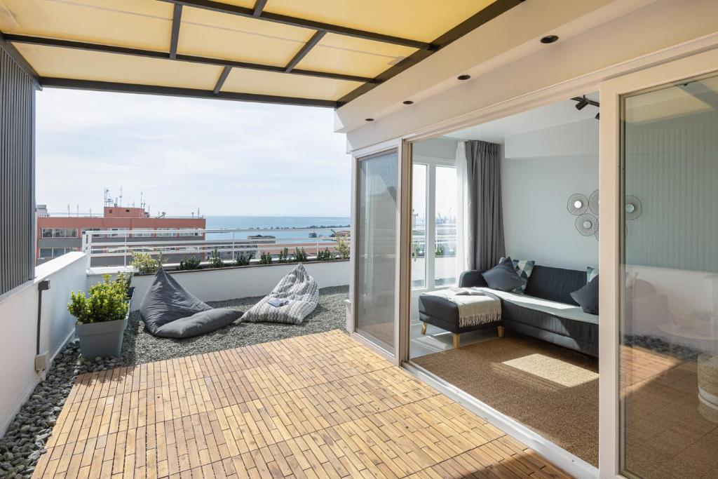 a balcony with a couch and a view of the ocean at Port de L'eau Roof Garden in Thessaloniki