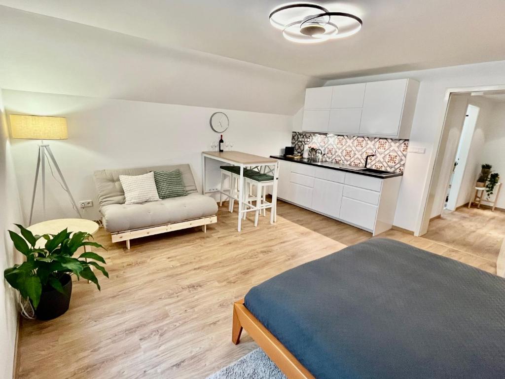 kuchnia i salon z łóżkiem i stołem w obiekcie Apartmány Dlouhá w Taborze