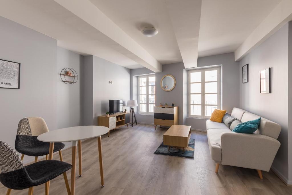 ein Wohnzimmer mit einem Sofa und einem Tisch in der Unterkunft La Tour - Appt climatisé pour 2 in Aubenas