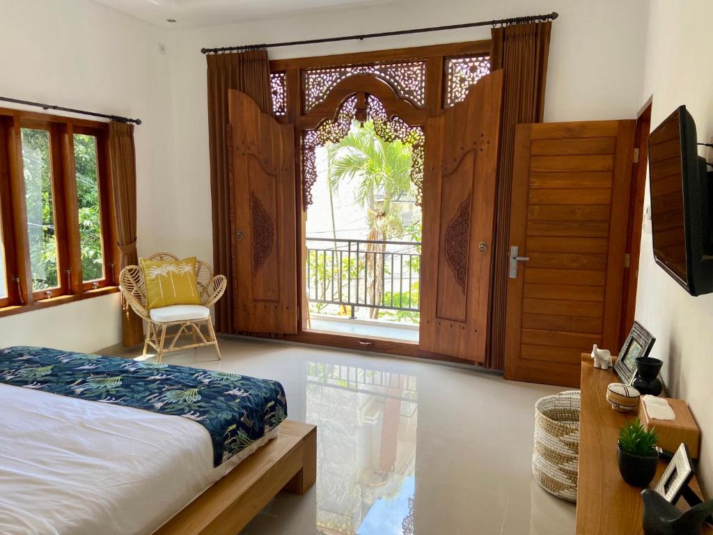 a bedroom with a bed and a large window at Villa Ayu Legian in Legian