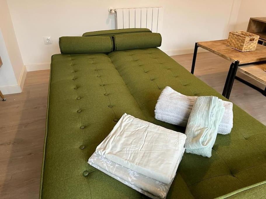 um sofá verde com duas almofadas num quarto em Ático a estrenar Ribamontán-Mar em Hoznayo