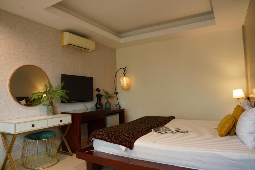 - une chambre avec un lit, un bureau et un miroir dans l'établissement Trang An Hotel - 5 minutes Landmark 81, à Hô-Chi-Minh-Ville