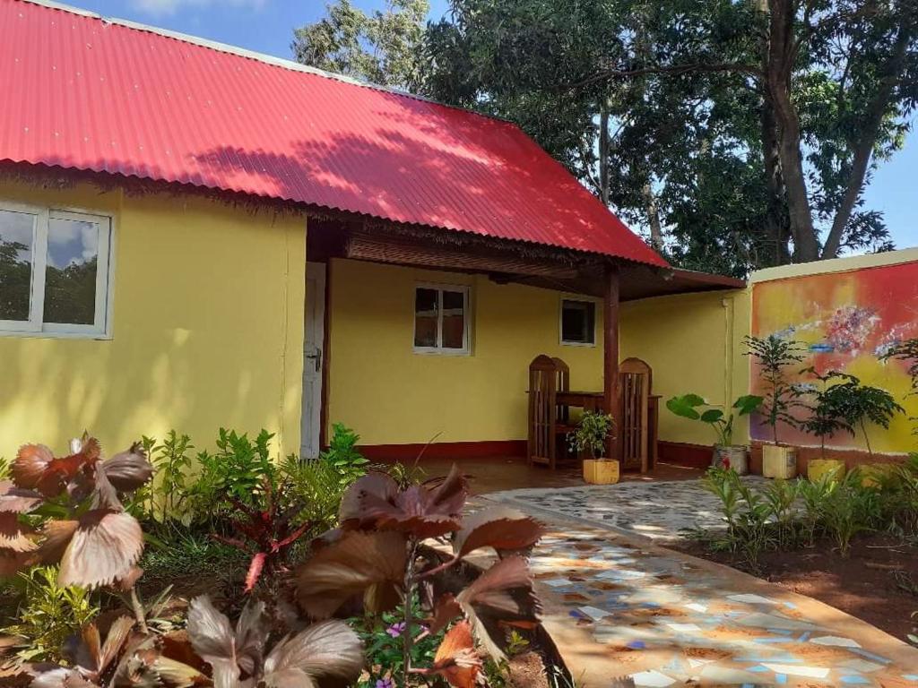 uma casa amarela com um telhado vermelho em Villa Meva em Antanamitarana Atsimo