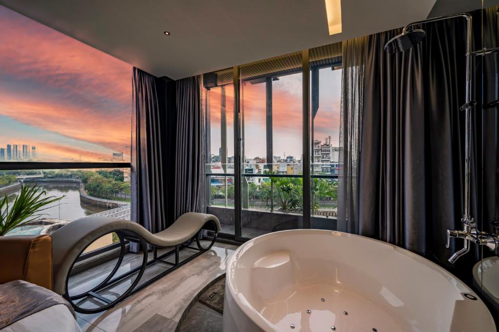 La salle de bains est pourvue d'une grande baignoire et d'une grande fenêtre. dans l'établissement Bonita Signature The View, à Hô-Chi-Minh-Ville
