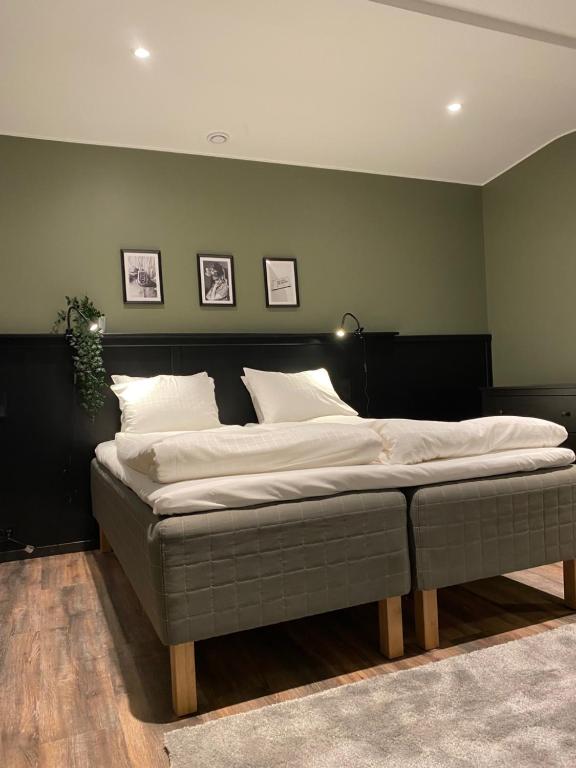 1 cama en un dormitorio con una pared verde en Magnolia House Sollentuna en Sollentuna