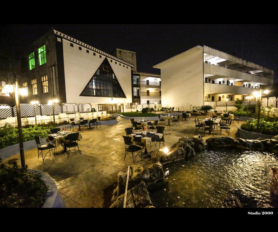 een restaurant met tafels en stoelen voor een gebouw bij Hotel Trupti International HUBLI in Hubli