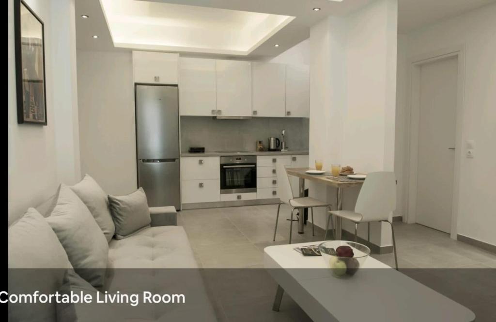 a white living room with a couch and a kitchen at SYNTAGMA VOULIS STREET MODERN APARTMENT in Athens