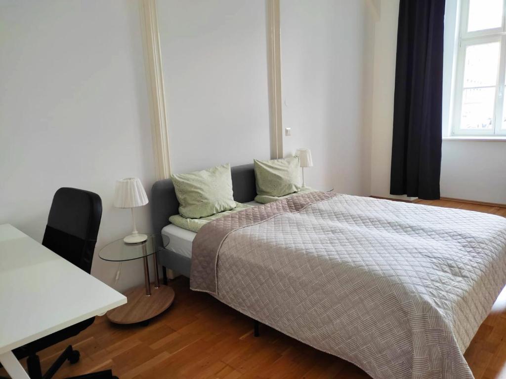 um quarto com uma cama, uma secretária e uma janela em Lovely Modern Historical 1-Bedroom em Viena