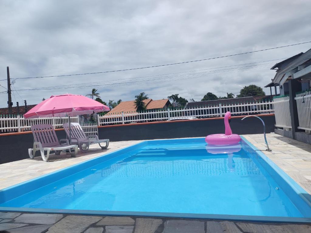 una piscina con un flamenco rosa en el medio en Apto com piscina 3 quartos 500m do mar praia Ubatuba en São Francisco do Sul