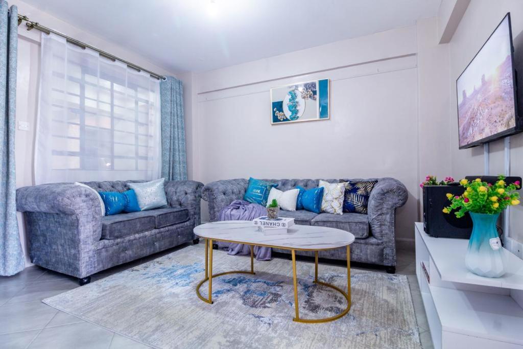 a living room with a couch and a table at Luxe Happy Home 254 Furnished Apartments in Nairobi
