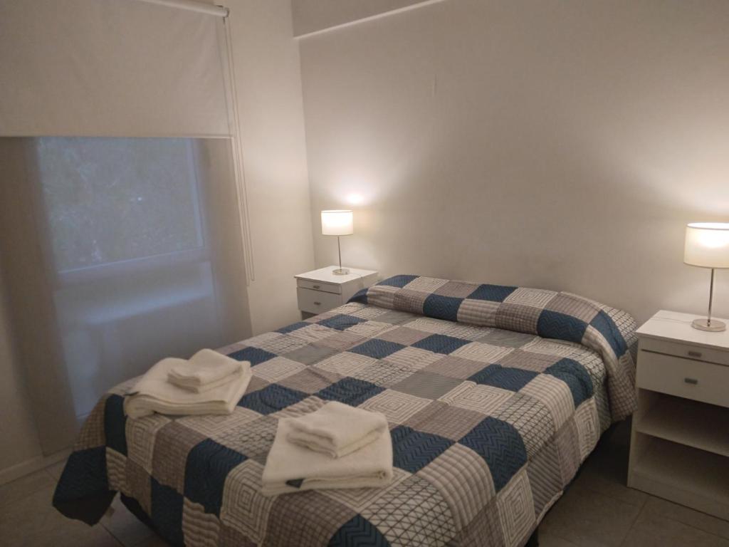 een slaapkamer met 2 bedden en handdoeken bij A 2 minutos caminando de la terminal. in Salta