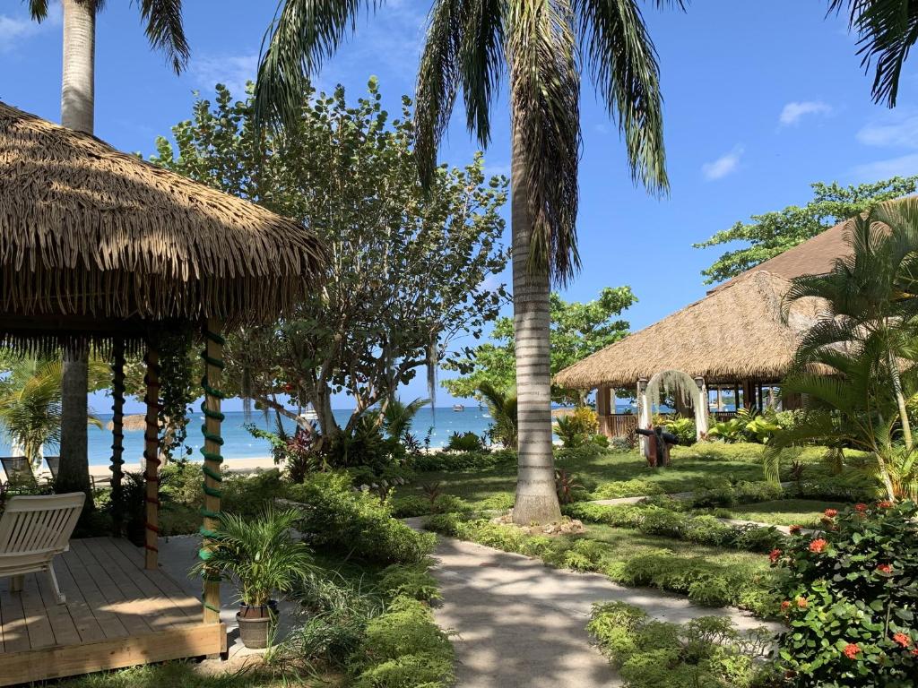 un complejo con un camino, palmeras y el océano en Relax in Jamaica - Enjoy 7 Miles of White Sand Beach! villa, en Negril