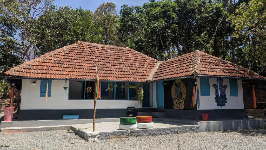 a small house with a tile roof at Crossroads Hostel 1957 in Wayanad