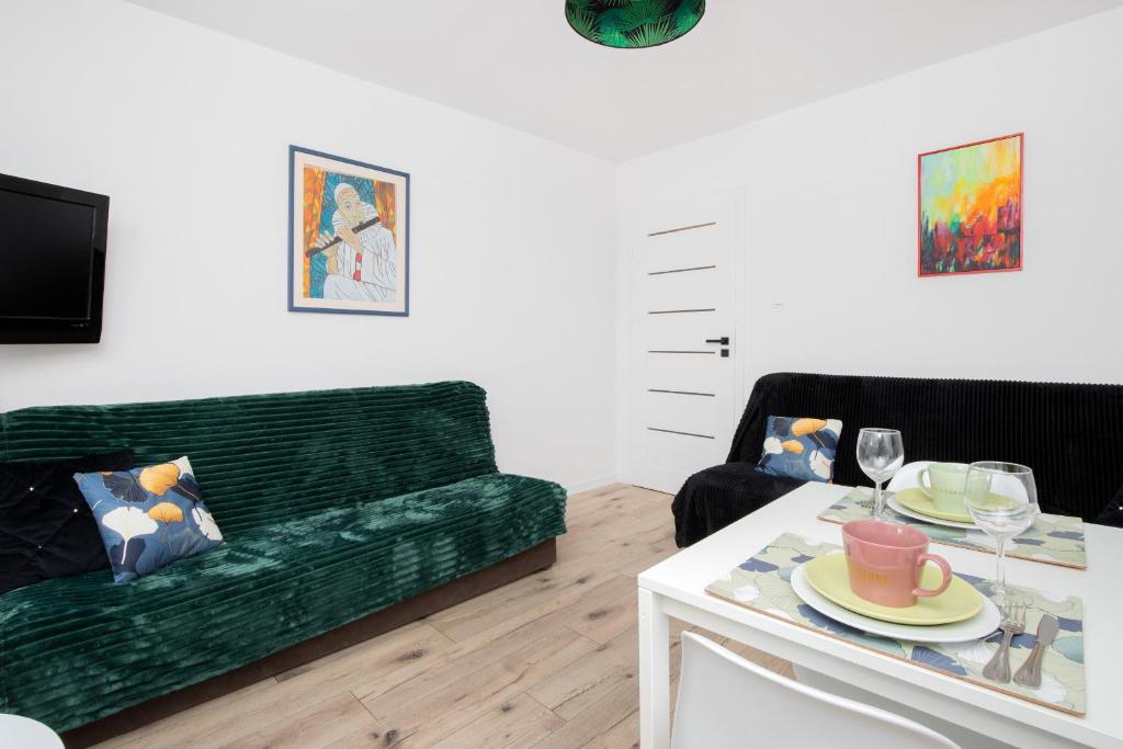 a living room with a green couch and a table at Warzywnicza Apartment Motława River by Renters in Gdańsk