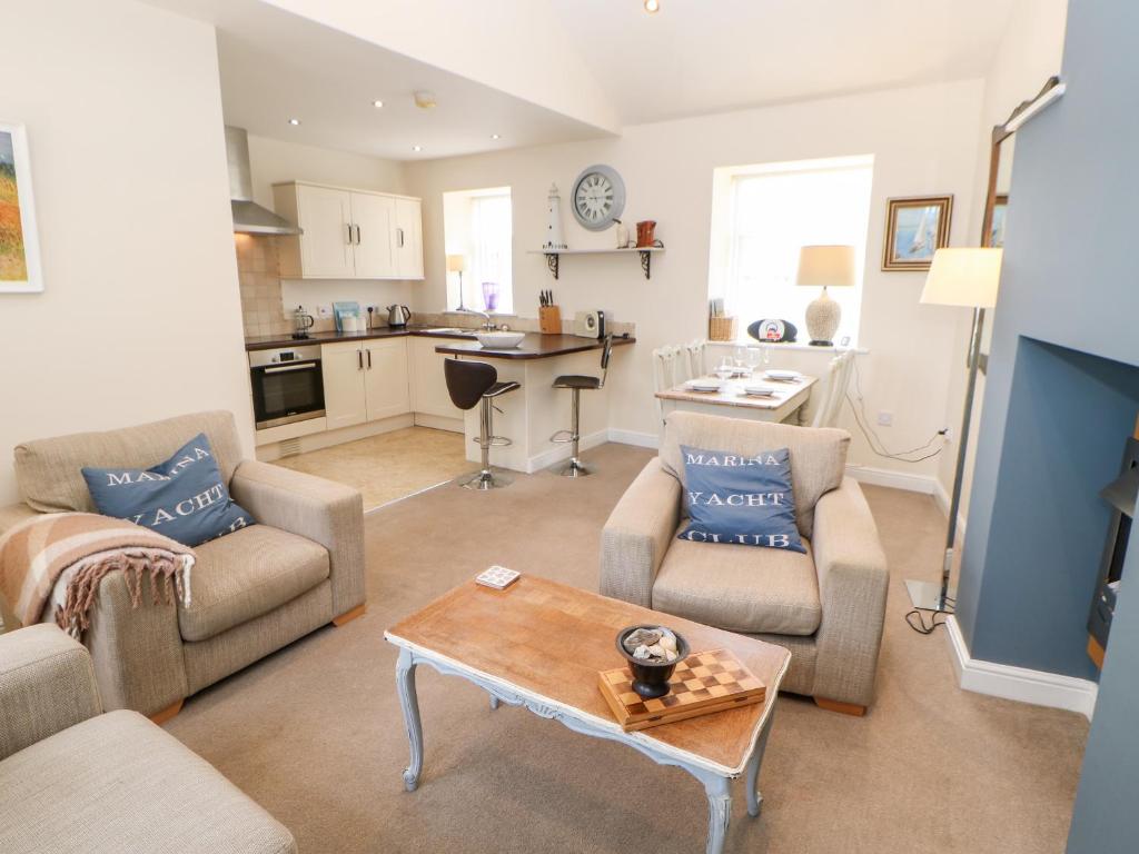 a living room with two couches and a table at Driftwood Apartment in Amble