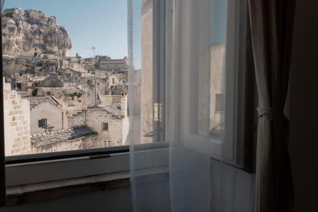 ein Fenster mit Stadtblick in der Unterkunft Il Vicinato, casa vacanza immersa nel cuore dei Sassi in Matera