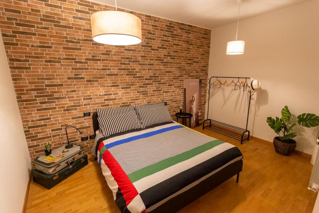 ein Schlafzimmer mit einem Bett und einer Ziegelwand in der Unterkunft a casa di Ale in Lucca